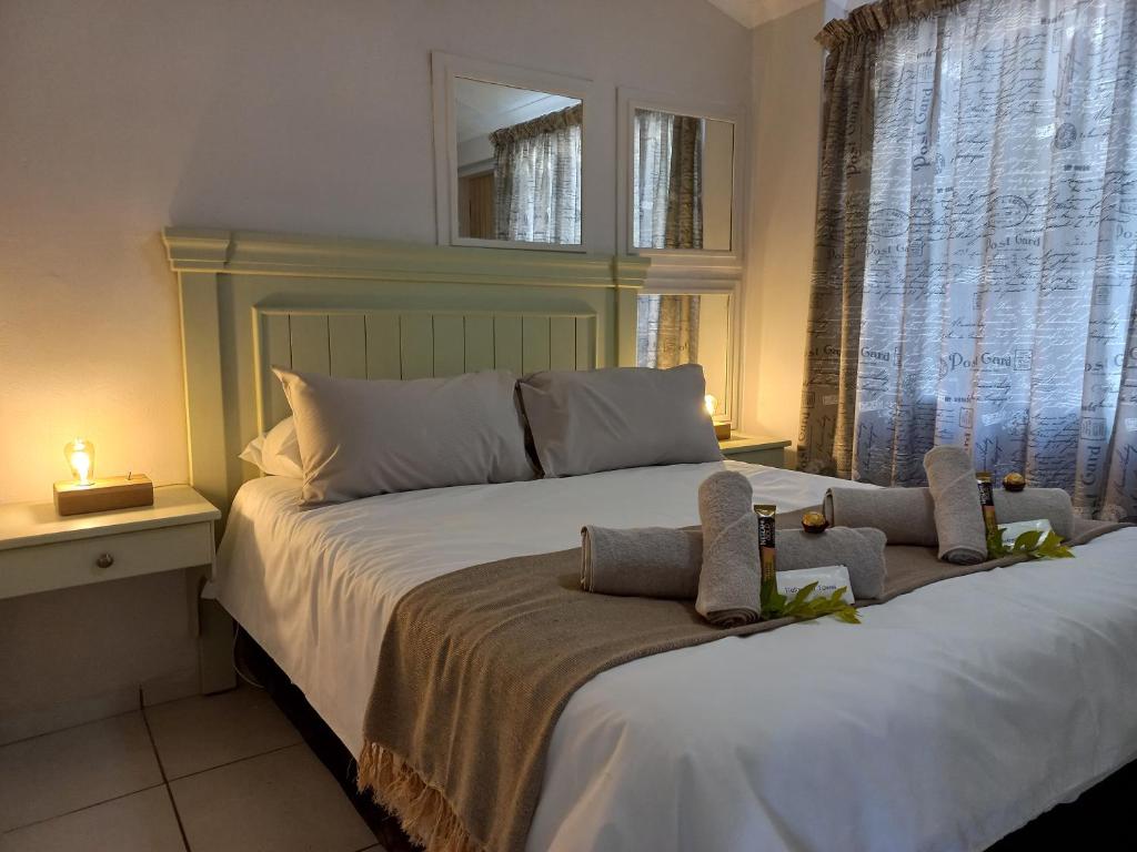 a bedroom with a large bed with two pillows on it at Lemon Tree Manor- Country Cottage in Groblersdal