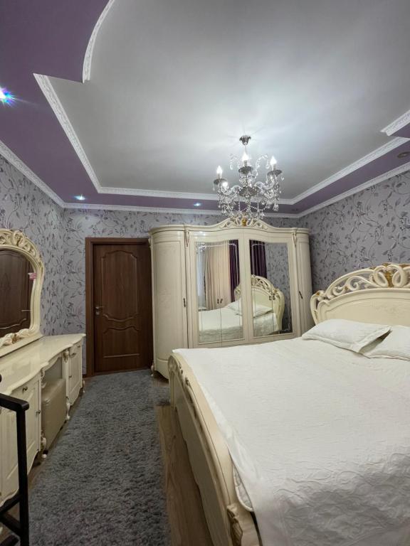 a bedroom with a bed and a dresser and a mirror at Ak-Orgo guest house in Bishkek