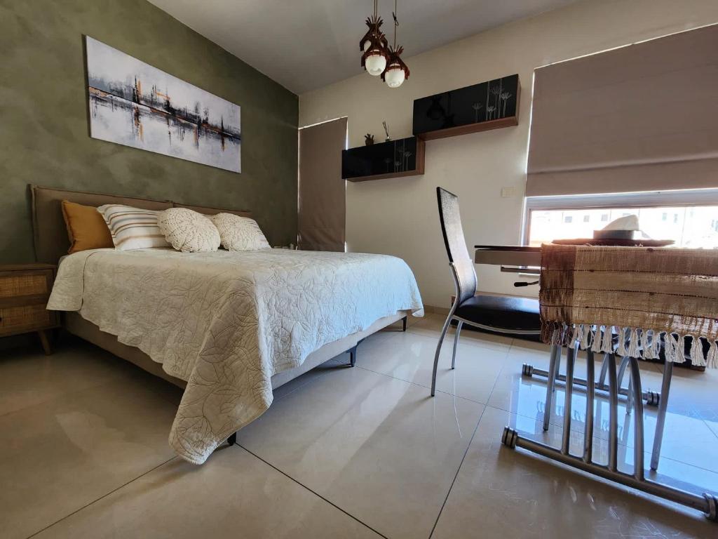 a bedroom with a bed and a desk and a piano at Jerusalems Nest in Jerusalem