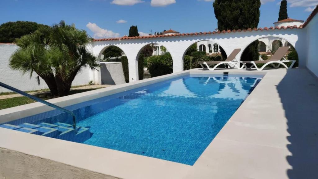 una piscina frente a una casa blanca en 009 Noguera, en Empuriabrava