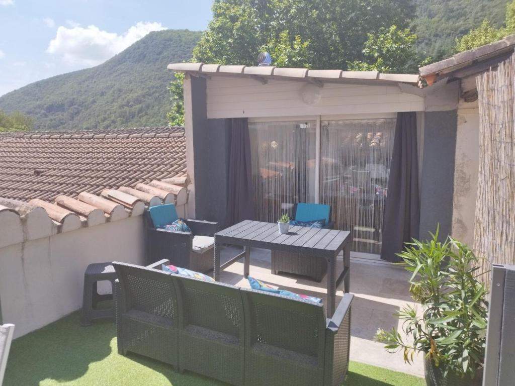 un petit patio avec une table et des chaises sur le toit dans l'établissement Charmant Appart cosy climatisé avec terrasse, à Bessèges