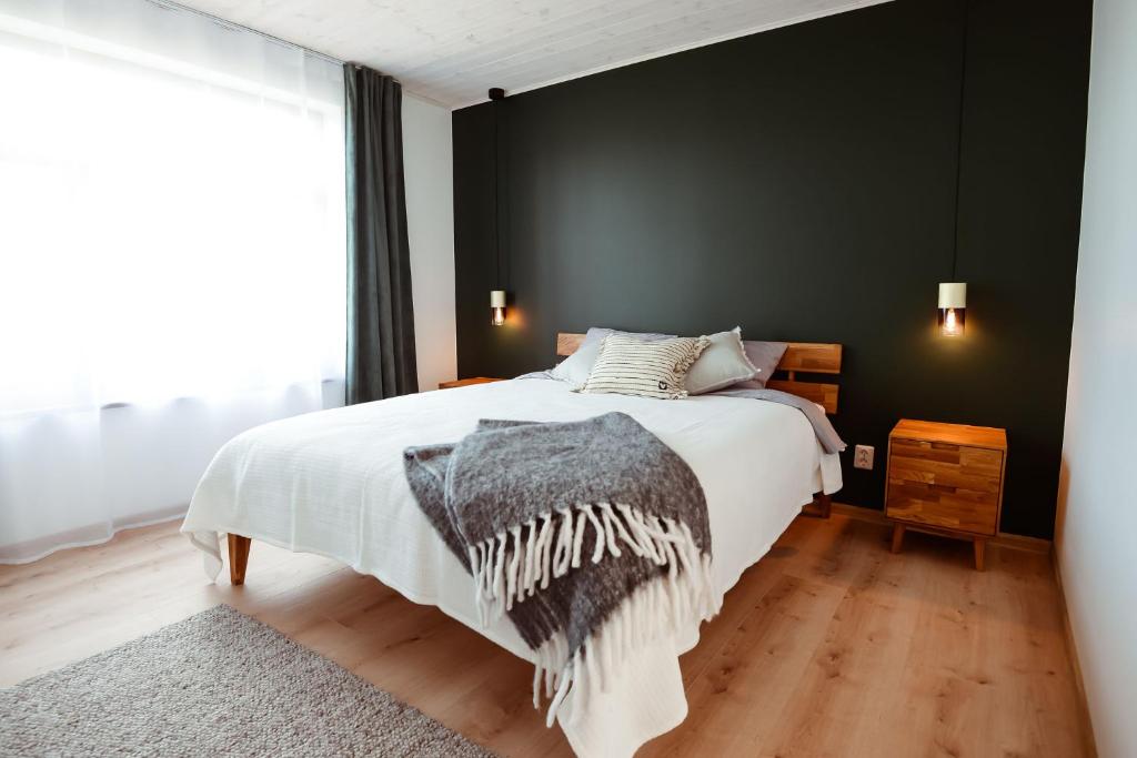 a bedroom with a bed and a black wall at MiMaMo in Põlva