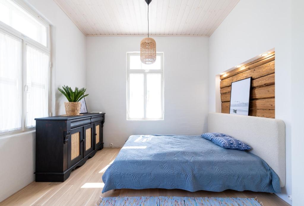 um quarto com uma cama, uma cómoda e janelas em Haapsalu OldTown apartment em Haapsalu