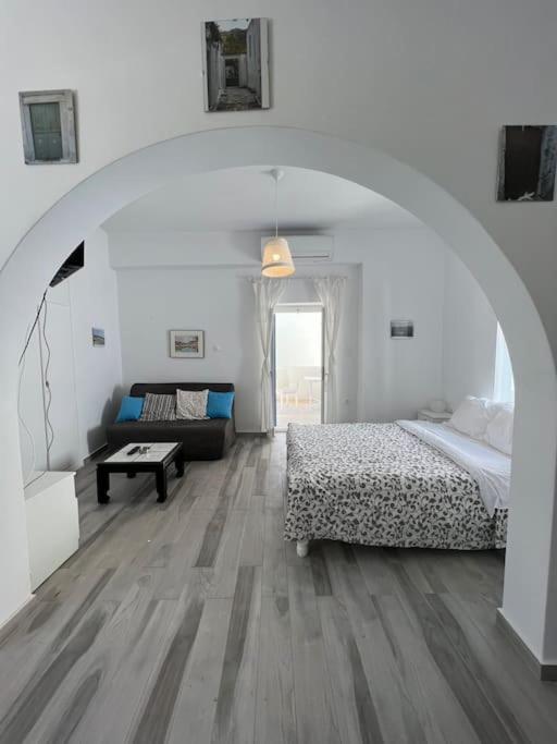 Una habitación blanca con una cama y un sofá. en Naxian Castle Gem Studio, en Naxos Chora