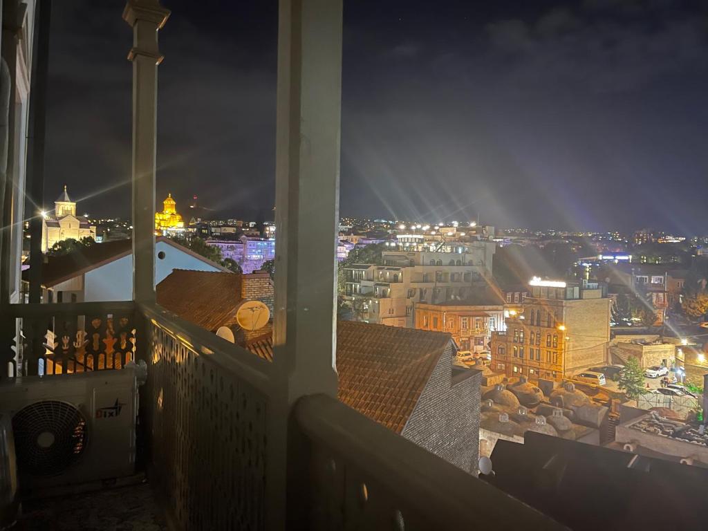 a view of a city at night from a balcony at Apartment On Botanikuri 17 in Tbilisi City