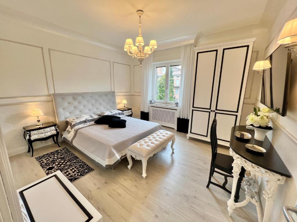 a bedroom with a bed and a table and a desk at Ghibellines Apartments in Verona