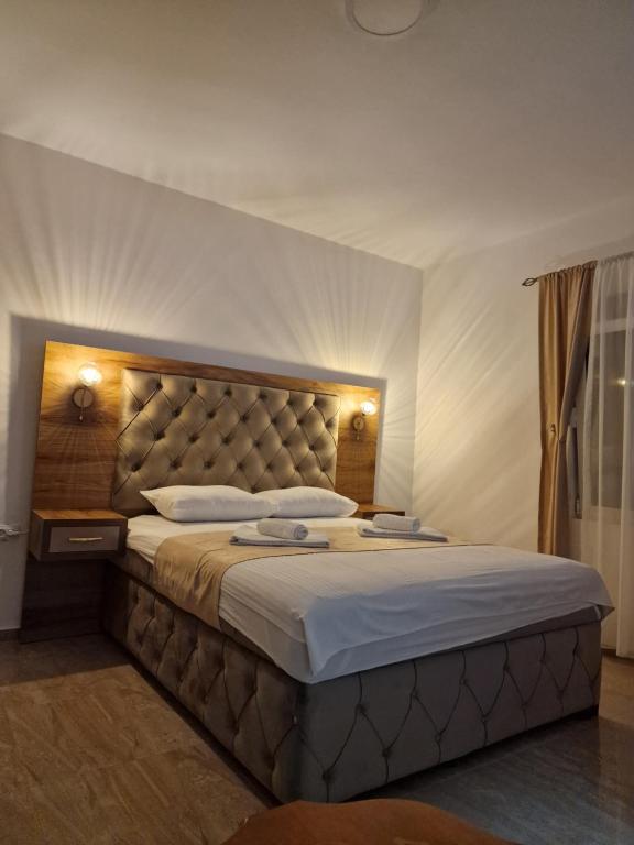 a bedroom with a large bed with a large headboard at Apartmani Enydoo in Ulcinj