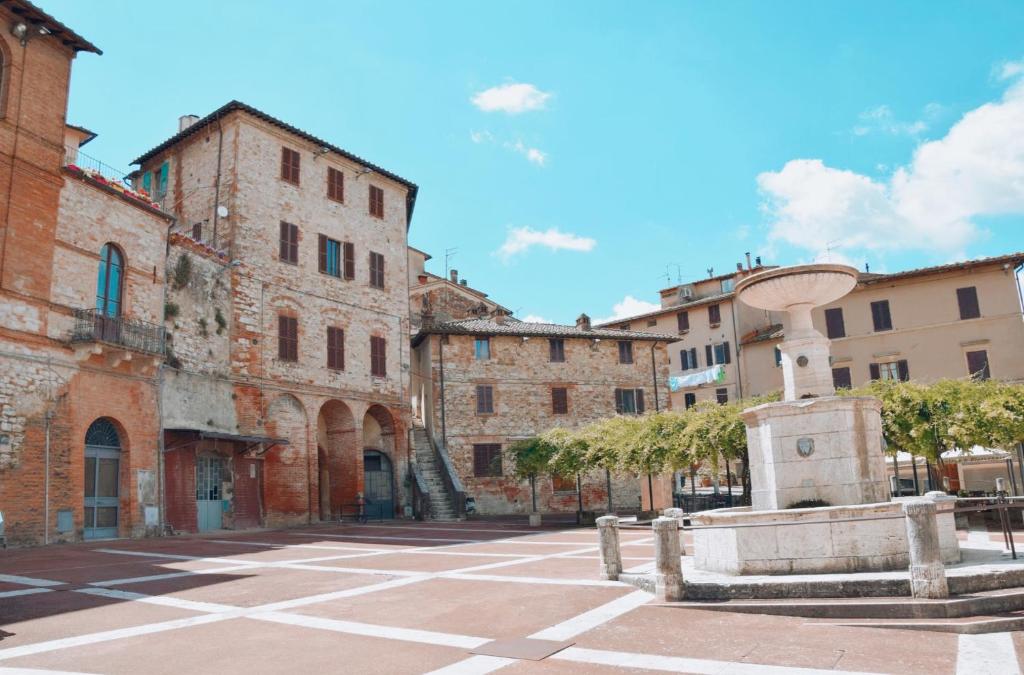 una strada in un centro storico con edifici di CS Holiday a Castelnuovo Berardenga