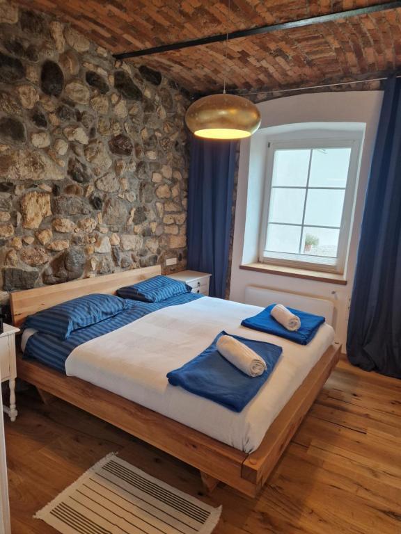 a bedroom with a large bed in a stone wall at Sobe Lotrist in Radovljica