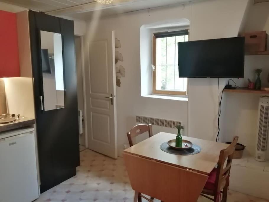 eine Küche und ein Esszimmer mit einem Tisch und Stühlen in der Unterkunft Petit studio au coeur d'Uzès in Uzès