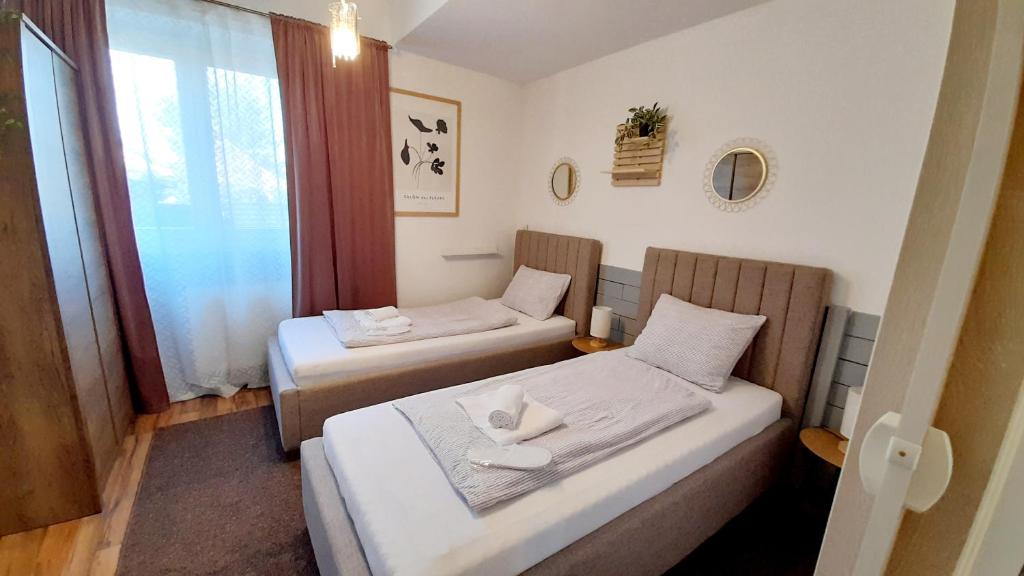 twee bedden in een kleine kamer met een raam bij Apartment Eleco in Bjelovar