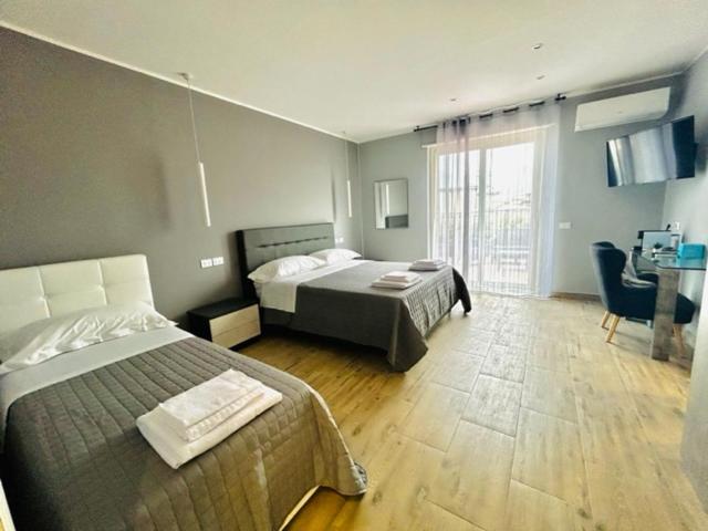 - une chambre avec 2 lits, un bureau et une fenêtre dans l'établissement Aqua B&B - Rooms and Apartments, à Milazzo