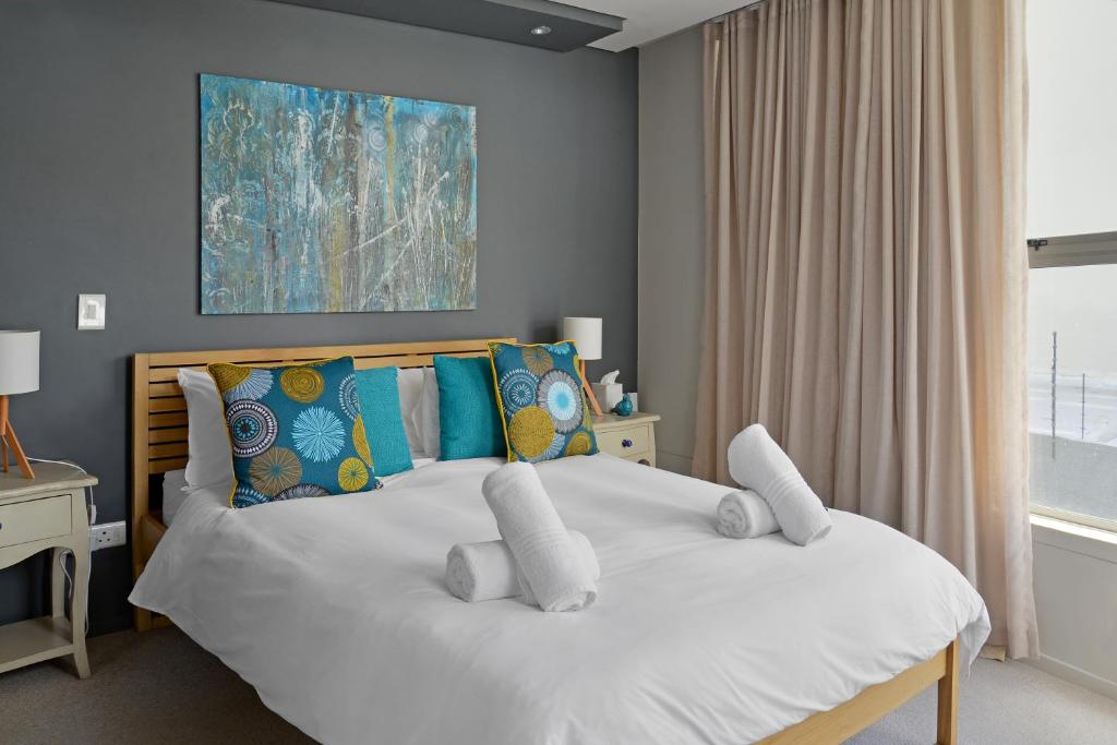 1 dormitorio con 1 cama blanca grande con almohadas en The Legacy 104, en Ciudad del Cabo