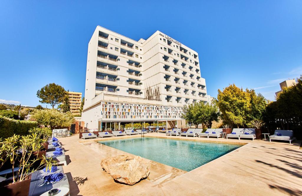 un hôtel avec une piscine en face d'un bâtiment dans l'établissement Leonardo Boutique Hotel Mallorca Port Portals - Adults only, à Portals Nous