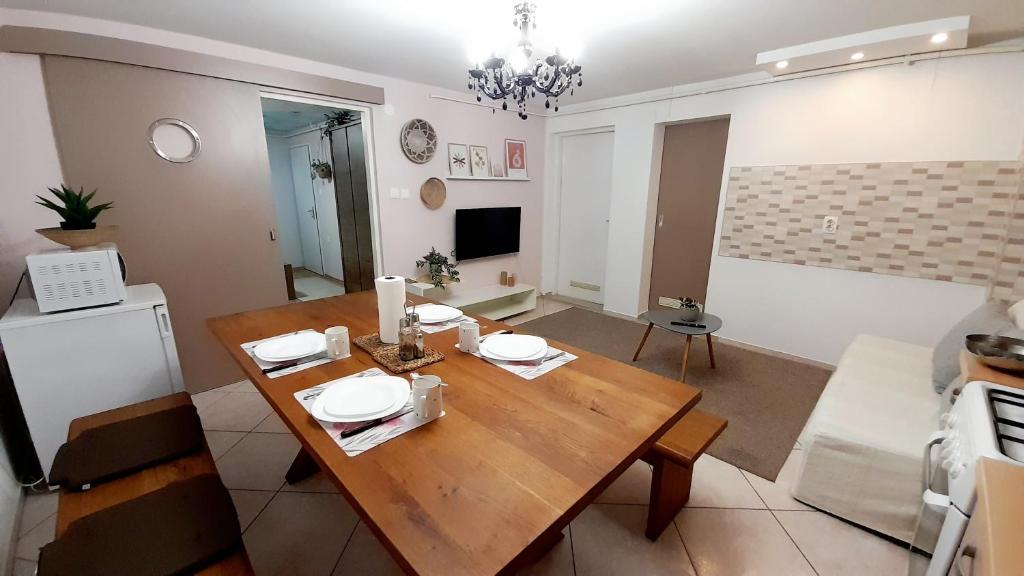 een woonkamer met een houten tafel en een keuken bij Apartment Eleco in Bjelovar