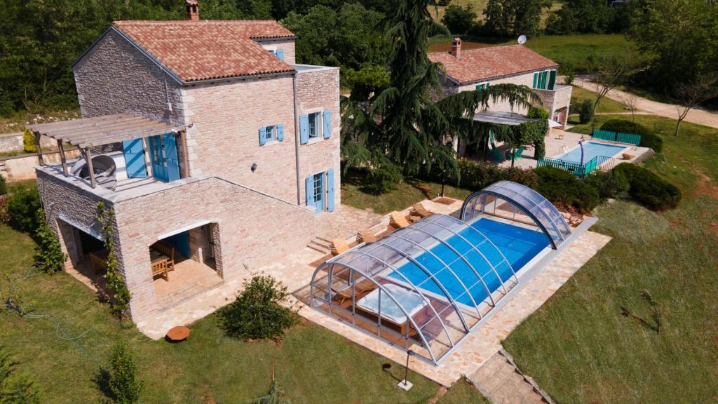 una vista aérea de una casa con piscina en Julijud, villa with heated pool, jacuzzi and sauna, en Brajkovići