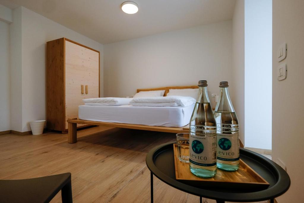 a room with two bottles on a table with a bed at Casa Carolina in Levico Terme