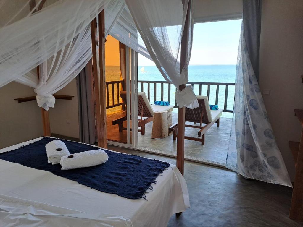 a bedroom with a bed with a view of the ocean at Komba on the Rocks in Nosy Komba