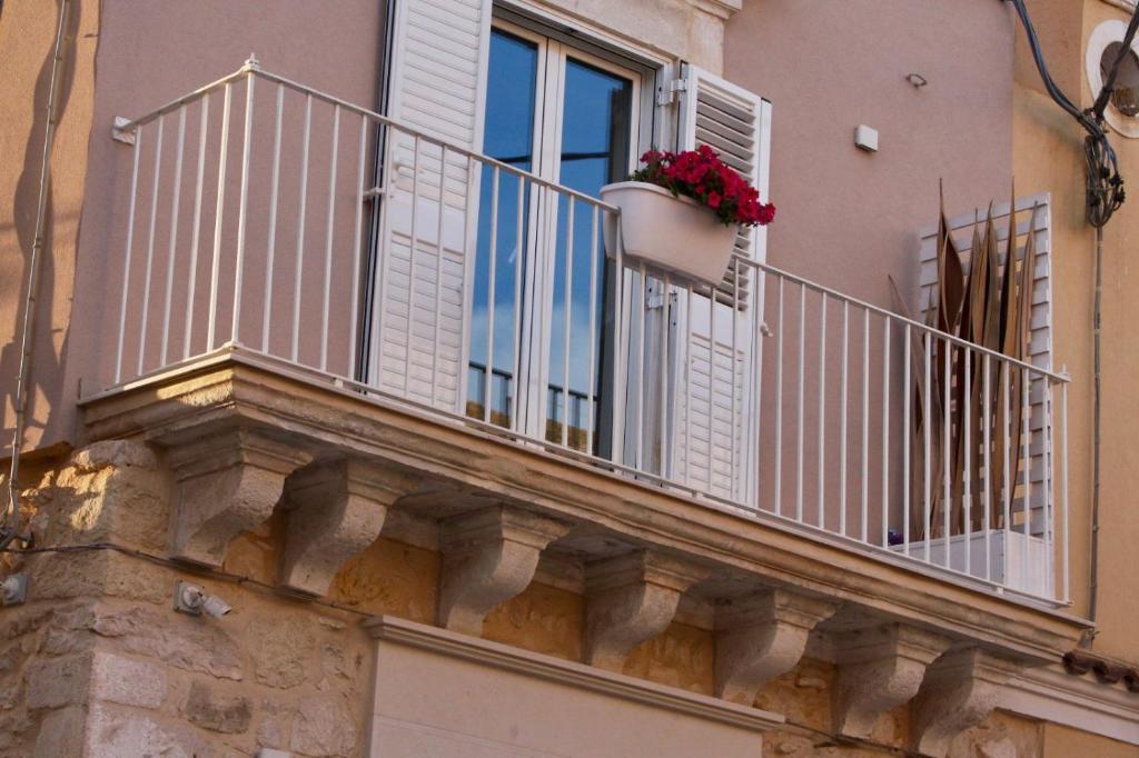 balkon z doniczką i oknem w obiekcie La casa di Nina w mieście Pozzallo