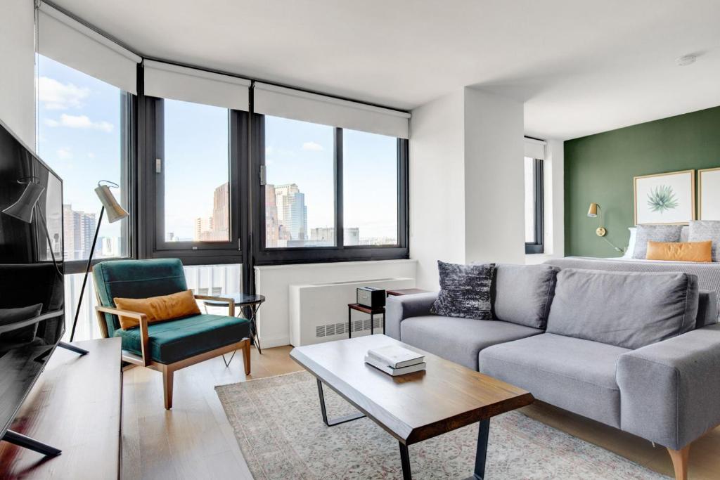 a living room with a couch and a table at Tribeca Studio w Pool Roofdeck Gym View NYC-273 in New York