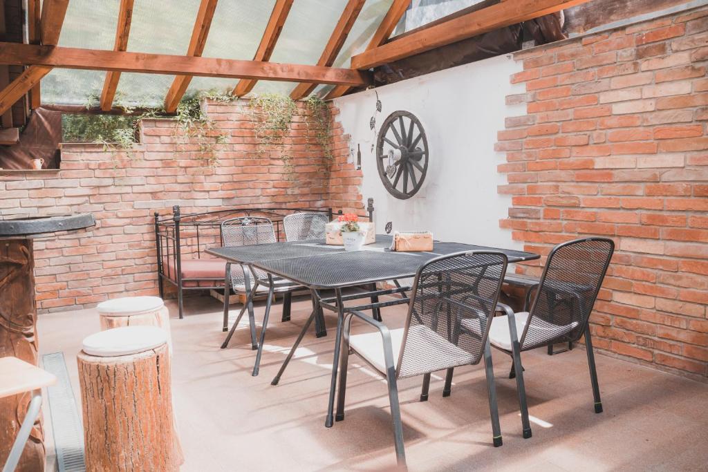 einen Tisch und Stühle in einem Zimmer mit Ziegelwand in der Unterkunft Chata - Sklep 57 in Starovice