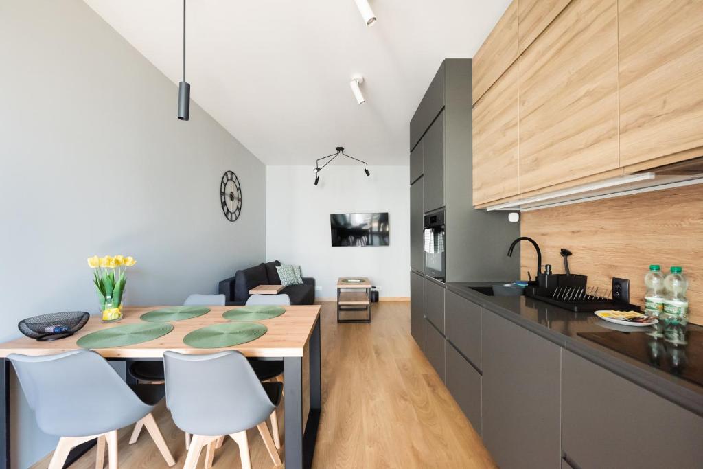 a kitchen and dining room with a table and chairs at Wola Skwer Happy Apartment in Warsaw