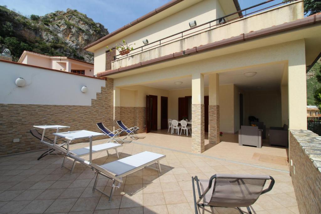 a patio with chairs and tables on a building at AM Bonagia Valderice VILLA INTERA in Valderice