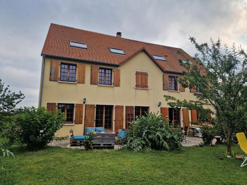 una grande casa con finestre in legno e un cortile di L'auberge d'authie a Authie