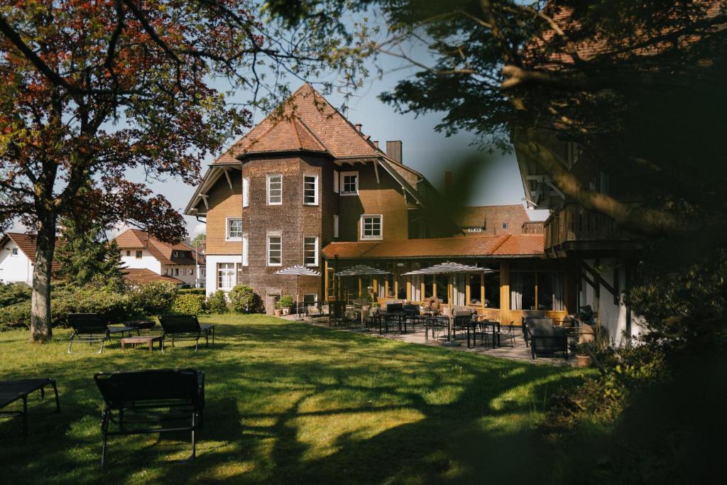 uma casa grande com mesas e cadeiras no quintal em Der Hirschen em Sankt Märgen