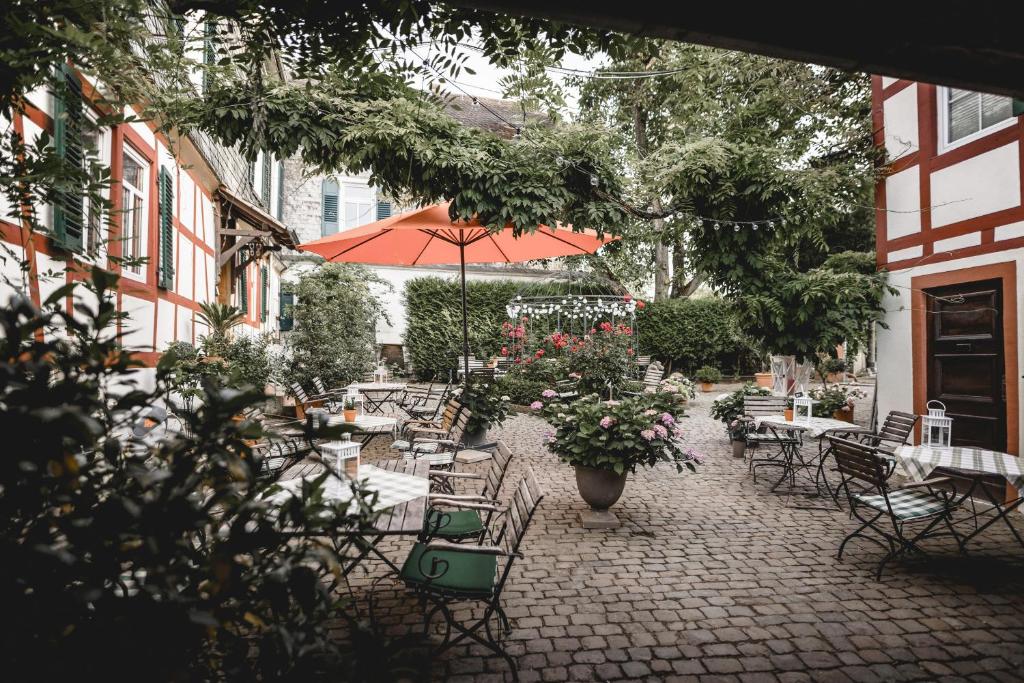 Klostermühle في إلتفيل: فناء في الهواء الطلق مع طاولات وكراسي وزهور