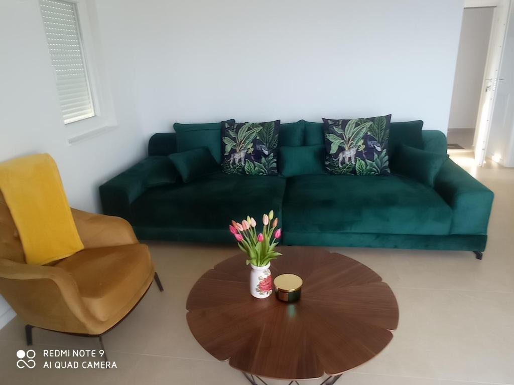sala de estar con sofá verde y mesa en Apartman sa dvije sobe, en Živogošće