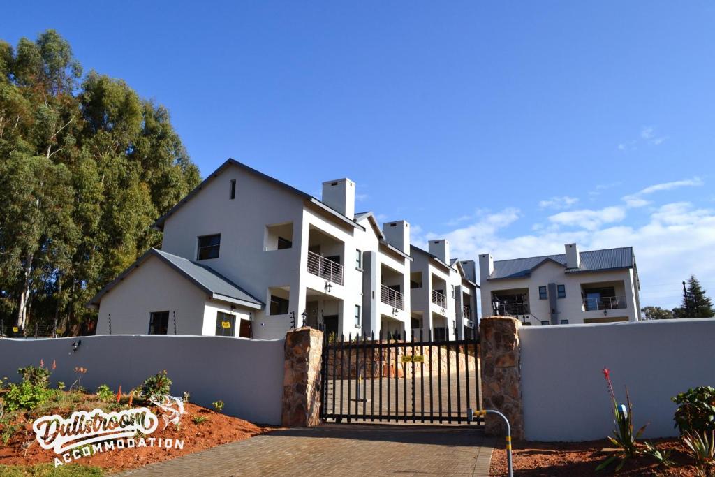 a large white house behind a white fence at Uitzicht in Dullstroom