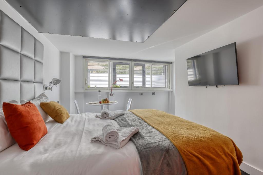 une chambre avec un grand lit et une télévision à écran plat dans l'établissement Branded New and Comfy Studio - Heart of Paris 3, à Paris