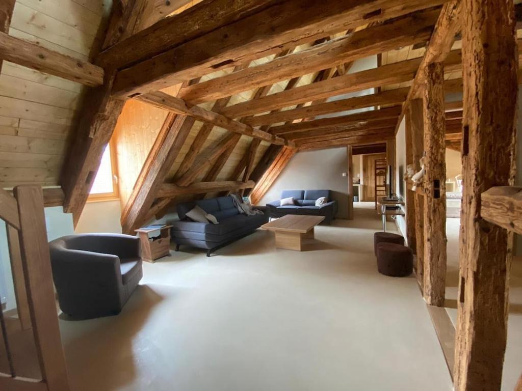 a large living room with wooden ceilings and furniture at Maison de charme en Alsace - IN VINO VERITAS - 12 personnes in Gueberschwihr