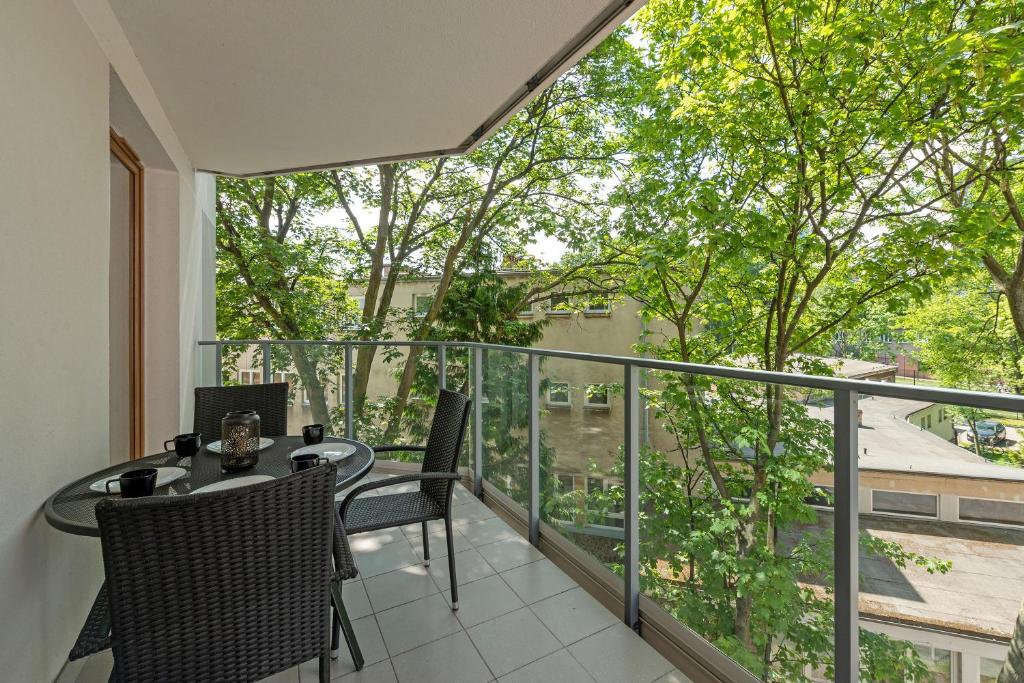 Hotel Gdańsk Centrum - Apartament 3 - pokojowy z dużym tarasem, a balcony with a table and chairs and a large window at Gdańsk Centrum - Apartament 3 - pokojowy z dużym tarasem in Gdańsk