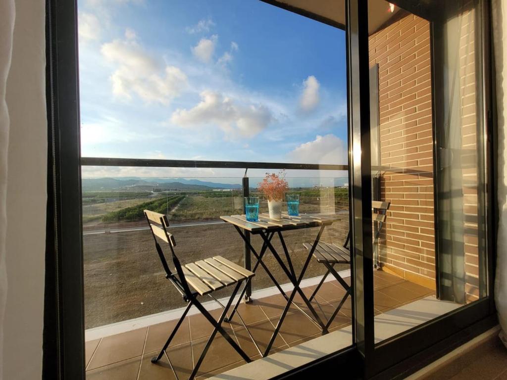 een tafel en stoelen op een balkon met uitzicht bij Apartamento Margalló con Garaje in Xilxes