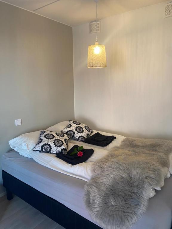 a bed in a room with pillows and a blanket at Moderni yksiö huippu sijainnilla in Jyväskylä