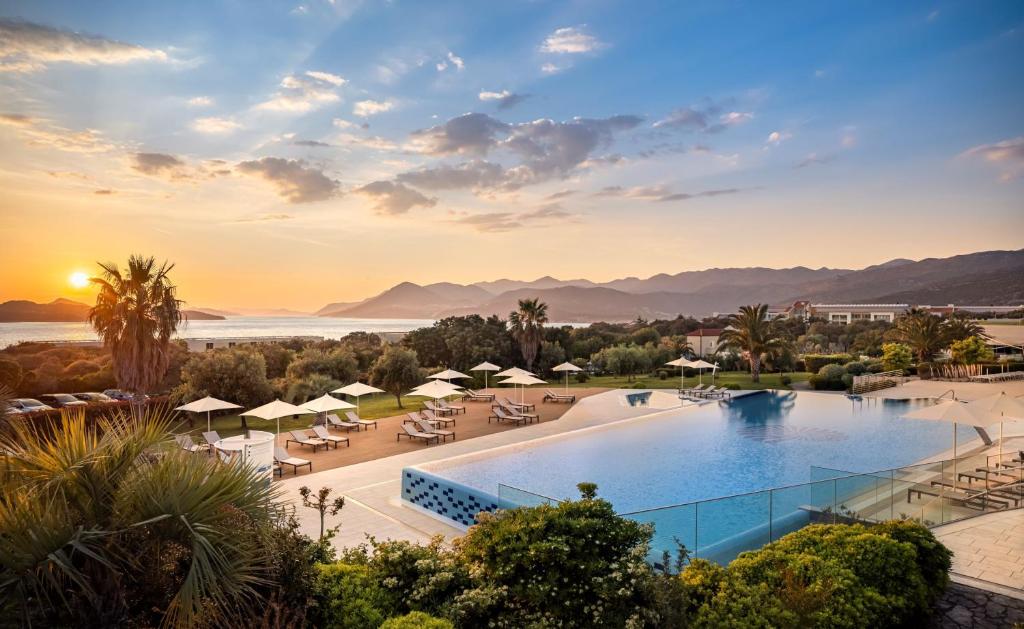 vista para a piscina num resort com um pôr-do-sol em Valamar Lacroma Dubrovnik Hotel em Dubrovnik