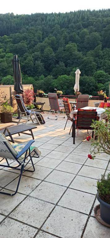 un grupo de sillas y mesas en un patio en Ferienwohnung mit Terrassen für 1-4 Personen, en Altena