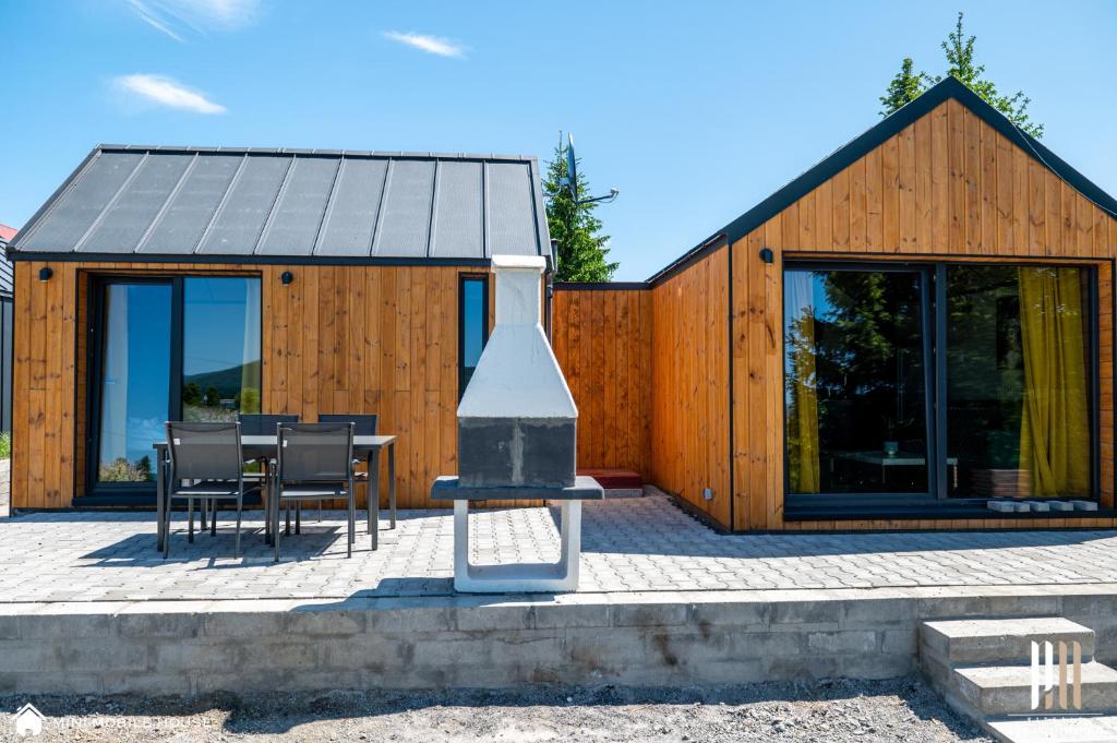 a wooden house with a table and chairs in front of it at Green Fields village in Sosnówka