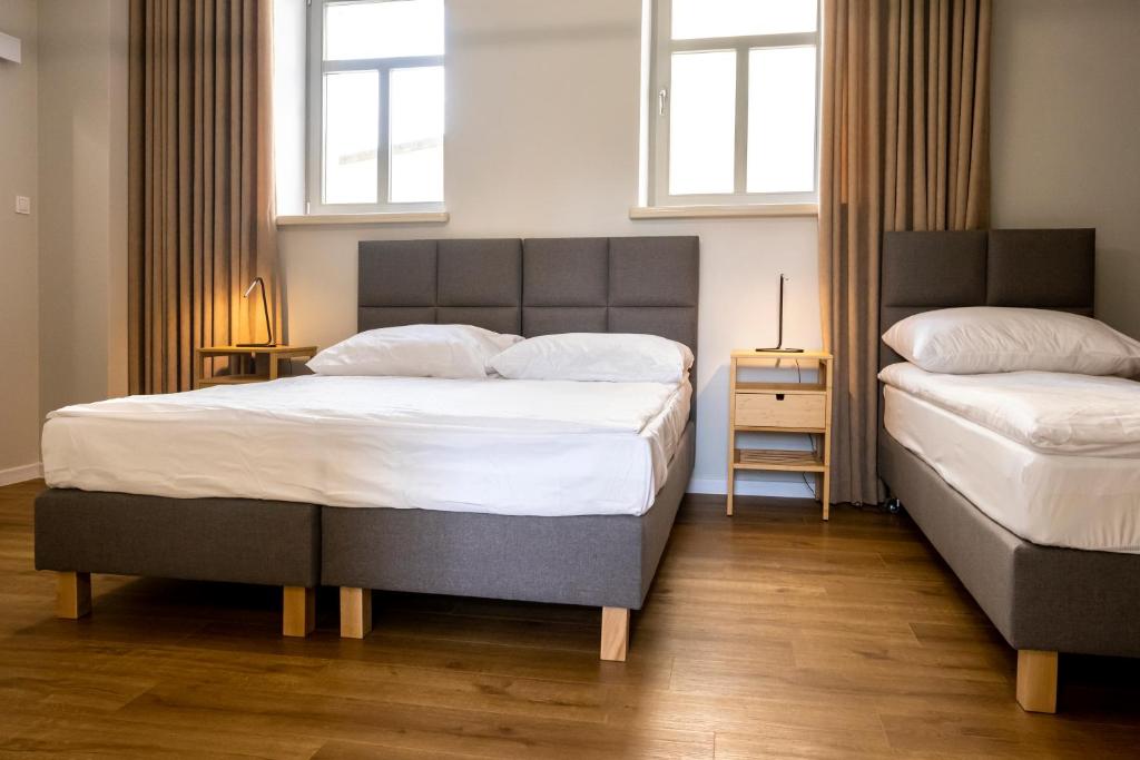 a bedroom with two beds and two windows at ORKANA House in Olsztyn
