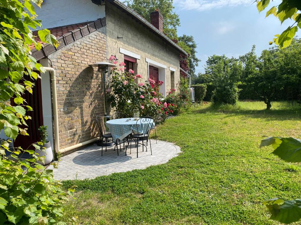 uma mesa e cadeiras sentadas fora de uma casa em Studio épicéa avec jardin dans charmante propriété em Méry-sur-Oise