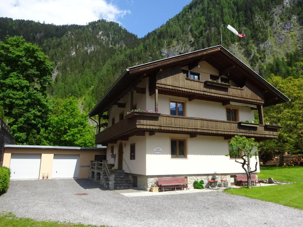 een huis met een gambrel dak en een garage bij Ferienwohnung Rita Kröll in Mayrhofen