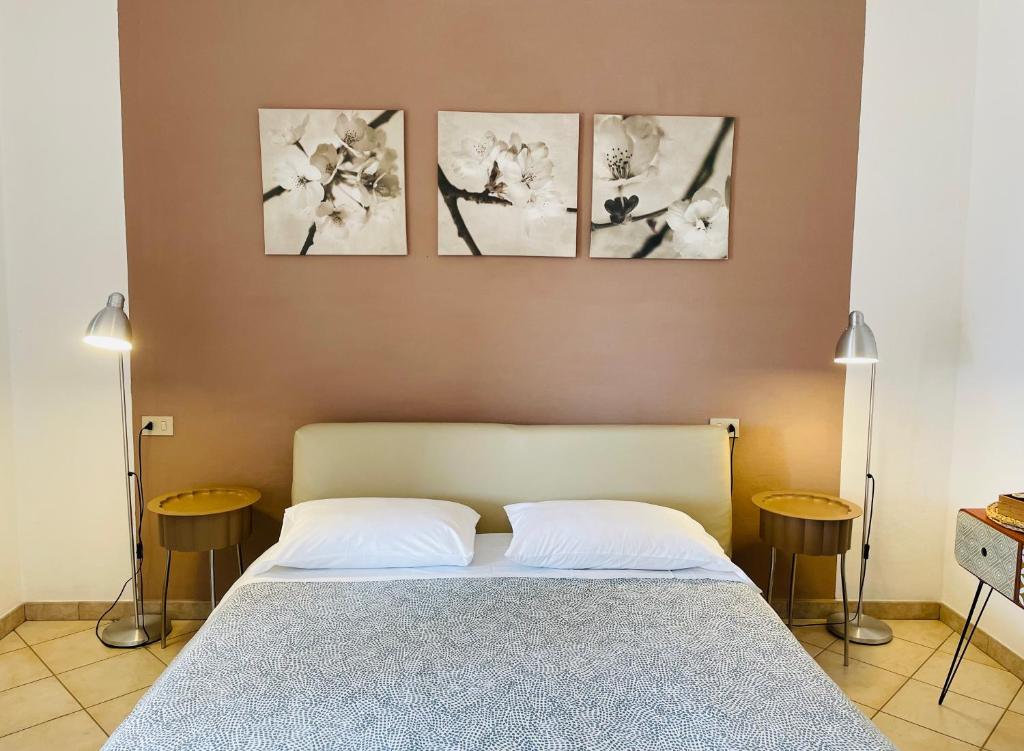 a bedroom with a bed with four pictures on the wall at B&B L'albero di Melograno in Seccheto