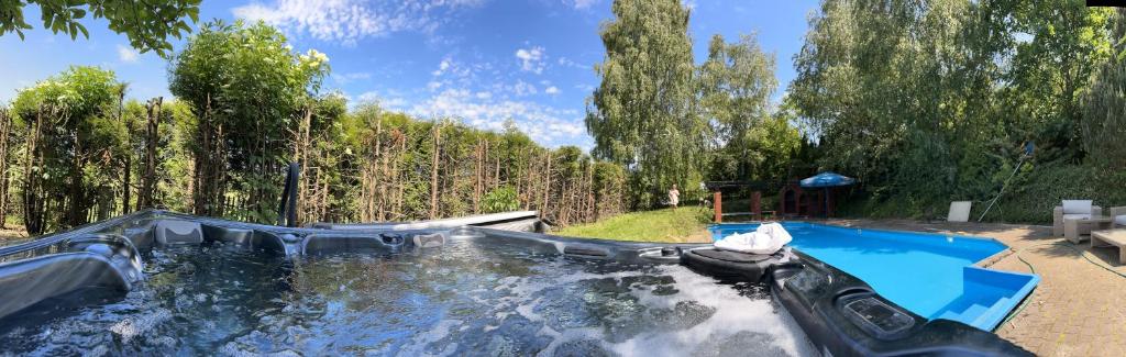 un tobogán de agua en un patio trasero con piscina en Willa 250 M z basenem, jacuzzi, ogrodem , tarasem oraz 2 hektary sadu , kominek i inne atrakcje 