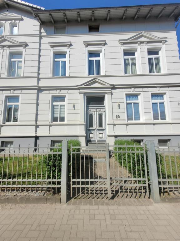 a white house with a fence in front of it at kleines Apartment in Wittenburg