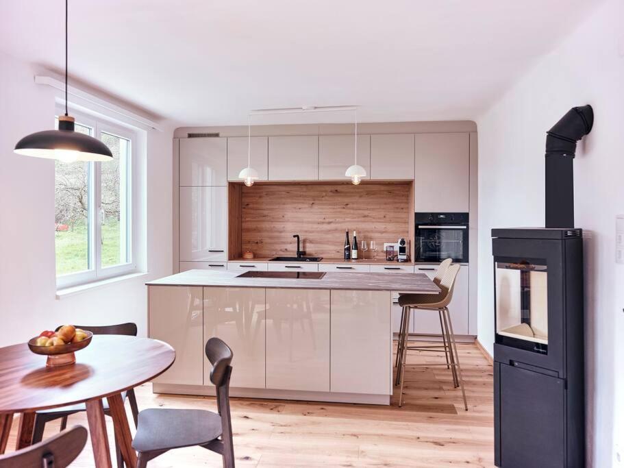 a kitchen with white cabinets and a table with chairs at Top Ferienhaus bei Spitz / Wachau in Schwallenbach