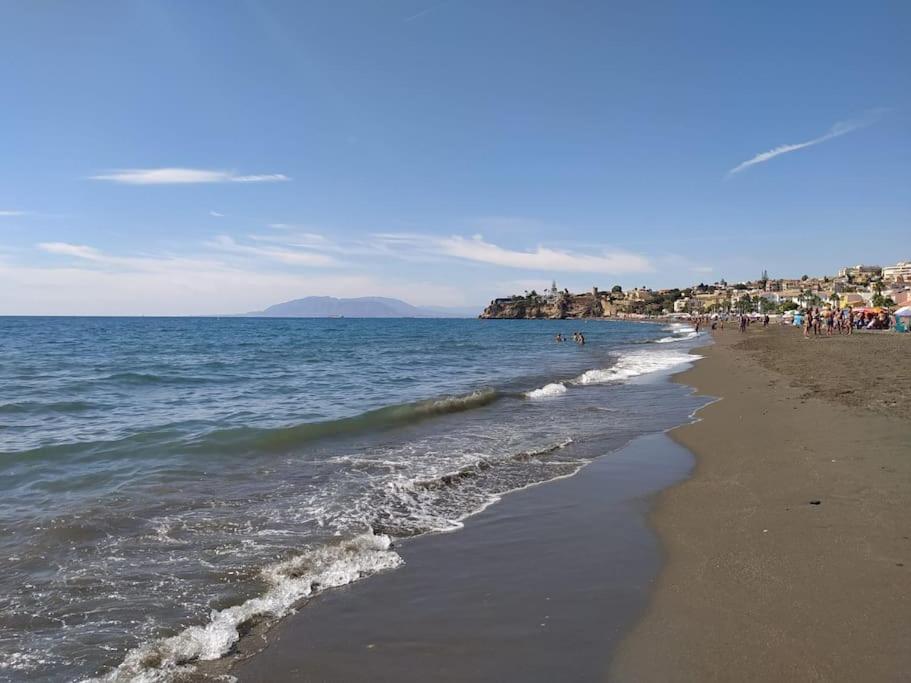 una spiaggia con un gruppo di persone e l'oceano di Estudio Rincon de la Victoria ( Malaga) a Rincón de la Victoria