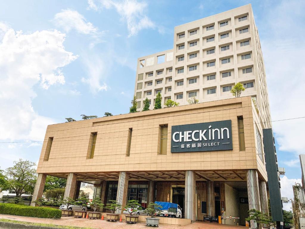 um edifício com uma placa na frente dele em CHECK inn Select Tainan Yongkang em Yongkang