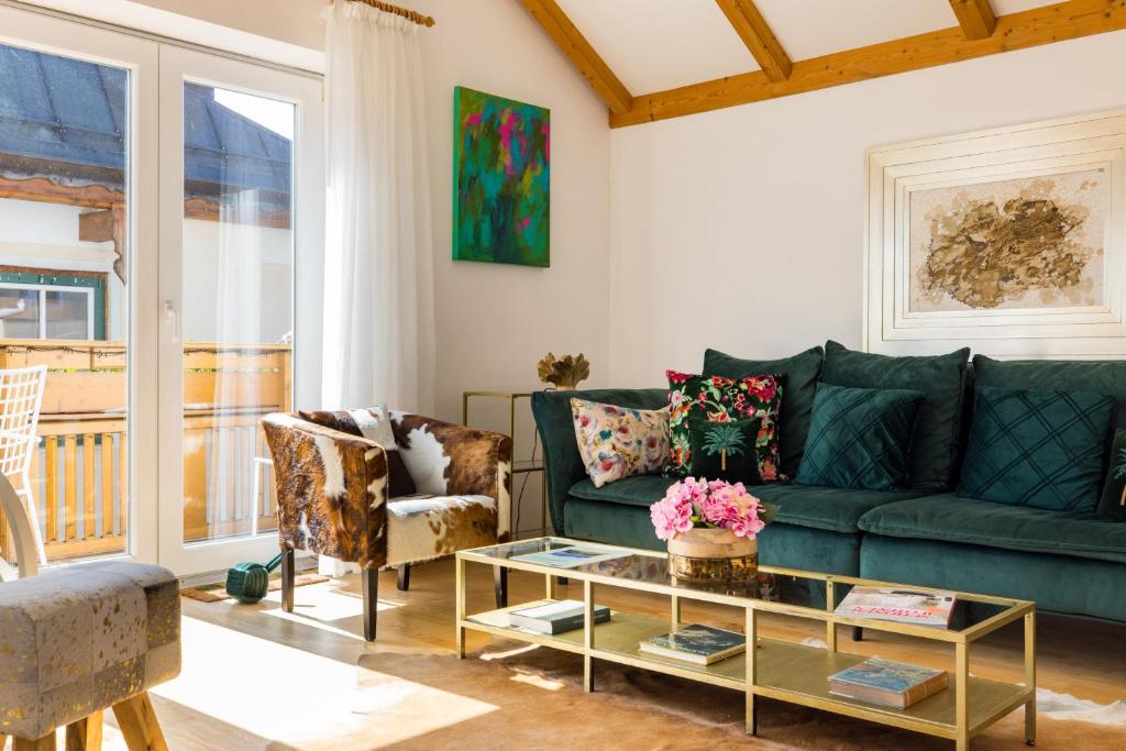 a living room with a green couch and chairs at Pfamhaus Penthouse in St. Wolfgang